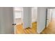 Hallway leading to the bathroom, featuring hardwood floors and closet at 9614 Quail Roost Rd, Bahama, NC 27503