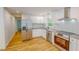 Bright, modern kitchen with stainless appliances, white cabinets, subway tile, and wood floors at 9614 Quail Roost Rd, Bahama, NC 27503