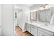 Bright bathroom boasts a double vanity with quartz countertops and a tiled shower at 100 Mill Creek Dr, Fuquay Varina, NC 27526