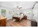 Bright bedroom with a wooden bed frame, a ceiling fan, and two bedside tables with lamps at 100 Mill Creek Dr, Fuquay Varina, NC 27526