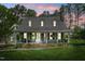Charming home featuring a welcoming front porch, dormer windows, and manicured lawn and beautiful landscaping at 100 Mill Creek Dr, Fuquay Varina, NC 27526