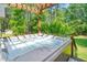 Outdoor hot tub with surrounding wooden deck, privacy fence, and backyard trees at 100 Mill Creek Dr, Fuquay Varina, NC 27526
