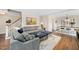 Inviting living room with a gray sectional sofa, blue ottomans, and warm wood flooring at 100 Mill Creek Dr, Fuquay Varina, NC 27526