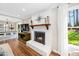 Cozy living room featuring a fireplace, hardwood floors, and natural light from a window at 100 Mill Creek Dr, Fuquay Varina, NC 27526