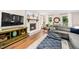 Cozy living room with a white brick fireplace, TV, gray sectional, and natural light at 100 Mill Creek Dr, Fuquay Varina, NC 27526