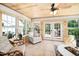 Bright sun room featuring wood paneled walls, a ceiling fan, neutral furniture, and a tile floor at 100 Mill Creek Dr, Fuquay Varina, NC 27526
