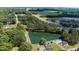 Overhead view featuring a neighborhood pond, houses, a pool, and roads against a backdrop of green fields and trees at 103 Rex Pl, Louisburg, NC 27549
