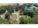 Expansive aerial view showcasing several homes and a tranquil pond surrounded by lush trees and green landscape at 103 Rex Pl, Louisburg, NC 27549