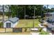 View of a fenced backyard featuring a shed, green lawn, trees, and a wooden deck attached to the house at 103 Rex Pl, Louisburg, NC 27549