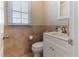 Half bath with tiled walls, white vanity, and natural light at 103 Rex Pl, Louisburg, NC 27549