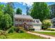 Charming home with a manicured lawn, mature trees, and red shutters at 105 Juniper Ct, Carrboro, NC 27510