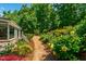 Lush landscaping with a winding path, beautiful bushes and plants on the side of the house at 105 Juniper Ct, Carrboro, NC 27510