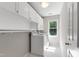 Bright laundry room with white cabinets, a window, and a washer and dryer at 105 Juniper Ct, Carrboro, NC 27510