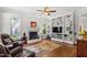 Elegant living room with built-in bookshelves, a fireplace, hardwood floors, and two windows at 105 Juniper Ct, Carrboro, NC 27510