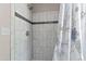 Shower featuring elegant white tile, a decorative accent stripe, and a shower curtain at 105 Juniper Ct, Carrboro, NC 27510