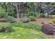 Backyard featuring greenery, landscaping, and house facade at 11035 Southwalk Ln, Raleigh, NC 27614