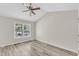 Neutral bedroom with wood-look floors, ceiling fan, and a window with a view of the yard at 11035 Southwalk Ln, Raleigh, NC 27614