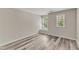 Bright bedroom featuring neutral walls, two windows, and wood-look floors at 11035 Southwalk Ln, Raleigh, NC 27614