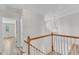 Hallway features wood and white banister, modern light fixture, and white walls at 11035 Southwalk Ln, Raleigh, NC 27614