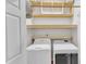 Well-lit laundry room features front load washer and dryer, shelving, and a hanging rod for storage at 11035 Southwalk Ln, Raleigh, NC 27614
