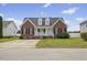 Charming brick home featuring a cozy front porch, black shutters, and lush green lawn at 1104 Cross Creek Dr, Nashville, NC 27856