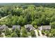 Overhead view of a neighborhood showcases a home with mature trees, a driveway, and lush landscaping at 112 Roseberry Way, Holly Springs, NC 27540