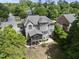 Expansive backyard and screened porch on a large gray house surrounded by lush trees and landscaping at 112 Roseberry Way, Holly Springs, NC 27540