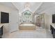 Bright bathroom featuring a soaking tub under a window, glass enclosed shower, and double sink vanity at 112 Roseberry Way, Holly Springs, NC 27540