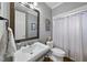 A well-lit bathroom features a pedestal sink, toilet, and shower with a clean white shower curtain at 112 Roseberry Way, Holly Springs, NC 27540