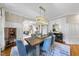 Elegant dining room featuring paneled walls, a modern chandelier, and stylish decor at 112 Roseberry Way, Holly Springs, NC 27540