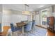 Bright dining room showcasing a modern chandelier, statement rug, and large windows at 112 Roseberry Way, Holly Springs, NC 27540