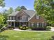 Charming brick home with a landscaped front yard and covered entryway offers classic curb appeal at 112 Roseberry Way, Holly Springs, NC 27540