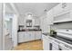 Contemporary kitchen boasts white cabinetry, stainless steel appliances, and hardwood floors at 112 Roseberry Way, Holly Springs, NC 27540