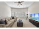 Living room featuring a couch, a TV, and a large window with natural light and a ceiling fan at 112 Roseberry Way, Holly Springs, NC 27540