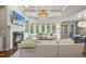 Spacious living room featuring a fireplace, TV, large windows, and an elegant chandelier at 112 Roseberry Way, Holly Springs, NC 27540