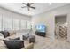 Living room featuring a couch, a TV, and a large window with natural light and a ceiling fan at 112 Roseberry Way, Holly Springs, NC 27540