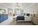This beautiful main bedroom offers a large window, bench and a comfortable blue comforter on the bed at 112 Roseberry Way, Holly Springs, NC 27540