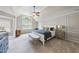 A bright and airy main bedroom with tray ceilings, a ceiling fan, and paneled walls at 112 Roseberry Way, Holly Springs, NC 27540