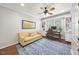 This home office features built-in shelves and cabinets, a ceiling fan, and a comfortable seating area at 112 Roseberry Way, Holly Springs, NC 27540