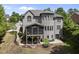 Expansive rear exterior view featuring a screened porch, upper deck, and manicured yard at 112 Roseberry Way, Holly Springs, NC 27540