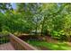 A beautiful backyard features lush landscaping, mature trees, and a view of a tranquil lake at 113 Wilander Dr, Cary, NC 27511
