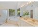 Bright bathroom with a soaking tub under a window, double sink vanity, and glass shower enclosure at 113 Wilander Dr, Cary, NC 27511