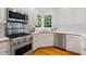 Modern kitchen featuring stainless steel appliances, white cabinetry, and hardwood floors at 113 Wilander Dr, Cary, NC 27511