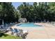 Community pool surrounded by lounge chairs, playground and mature trees, creating a perfect spot for relaxation at 113 Wilander Dr, Cary, NC 27511