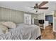 Comfortable bedroom featuring wood paneling, ceiling fan, plenty of natural light, and wood-look flooring at 1169 Clayhole Rd, Dunn, NC 28334