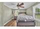 Cozy bedroom with wood paneling, ceiling fan, large windows, and wood-look flooring at 1169 Clayhole Rd, Dunn, NC 28334