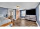 Bright bedroom with modern wood floors, a large TV, and ample closet space for storage at 1169 Clayhole Rd, Dunn, NC 28334