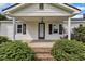 Charming front porch with classic white columns, brick steps, and meticulously maintained landscaping at 1169 Clayhole Rd, Dunn, NC 28334