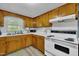 The kitchen features wood cabinets and white appliances near the sink with a window view at 1169 Clayhole Rd, Dunn, NC 28334