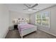 Cozy bedroom with a comfortable queen-size bed, ceiling fan, and large windows with views of the backyard at 123 Terawood Farm Dr, Willow Springs, NC 27592